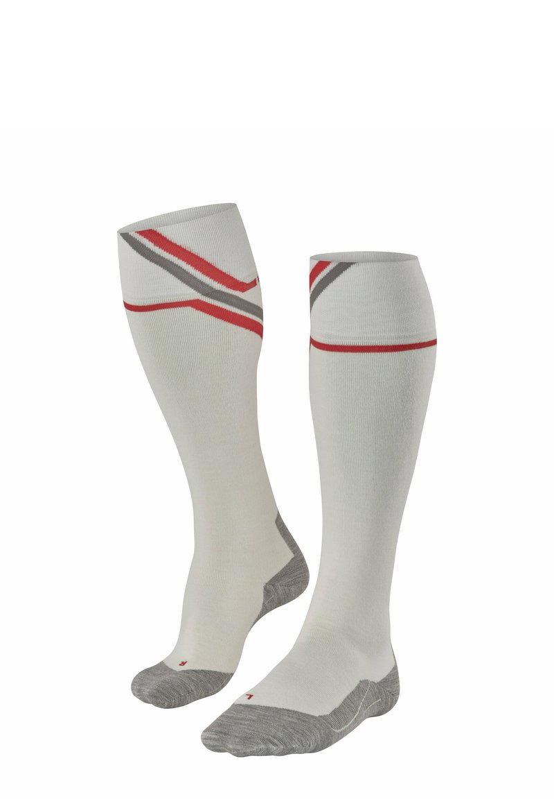 Chaussettes jusqu'au genou de couleur crème clair avec des rayures rouges et grises. Fabriquées en tissu doux, avec une zone de pied et de talon renforcée en gris.