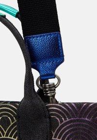 Svart tygväska med rem i metallblå detaljer, med en silverfärgad metallklipp och texturerade inslag, som visar färgglada mönster.