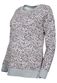 Pull de maternité rose pâle avec un motif floral bleu marine et gris. Présente des poignets côtelés gris et des boutons sur le côté pour un ajustement.