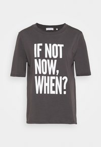 Camiseta de algodón gris con mangas cortas y cuello redondo, que presenta un llamativo texto en blanco: "¿SI NO AHORA, CUÁNDO?" destacado en la parte frontal.