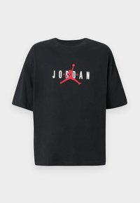 Crna majica s kratkim rukavima od pamuka s velikim crvenim logom "JORDAN" i grafikom siluete u sredini.