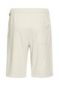 Lys beige shorts lavet af blødt stof. Har en elastisk talje, snøre og en enkelt baglomme med syninger.