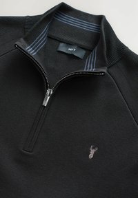 Schwarzer Reißverschluss-Pullover mit geripptem Kragen, blauen Streifenakzenten, strukturiertem Stoff und einem kleinen gestickten Emblem auf der Vorderseite.