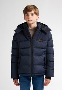 Jachetă puffer albastru închis, cu fermoar în față, buzunare frontale și glugă. Prezintă un finisaj texturat și un patch cu logo pe piept.
