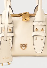 Krém színű bőr kézitáska arany színű zárszerkezettel, cipzárral, csatokkal és madár logó emlémával az elején, a Pinko márkanevével a címkén.