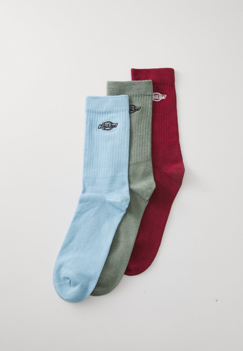 Tres pares de calcetines de algodón en azul claro, verde oliva y burdeos, con textura acanalada y un pequeño logo negro en el lateral.