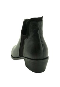 Botín negro hasta el tobillo con un acabado de piel sintética texturizada, tacón bajo en bloque, paneles laterales elásticos y puntera redondeada.