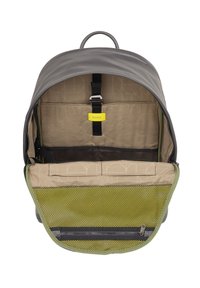 Zaino grigio con una parte superiore arrotondata, dotato di un'etichetta gialla, tasca in rete e interno beige con rivestimento a fantasia. Comparto con zip in fondo.