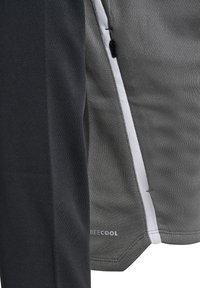 Maglietta atletica a maniche corte in grigio scuro e grigio chiaro, caratterizzata da un tessuto texturizzato, con zip laterale e una cucitura bianca a contrasto lungo il bordo.
