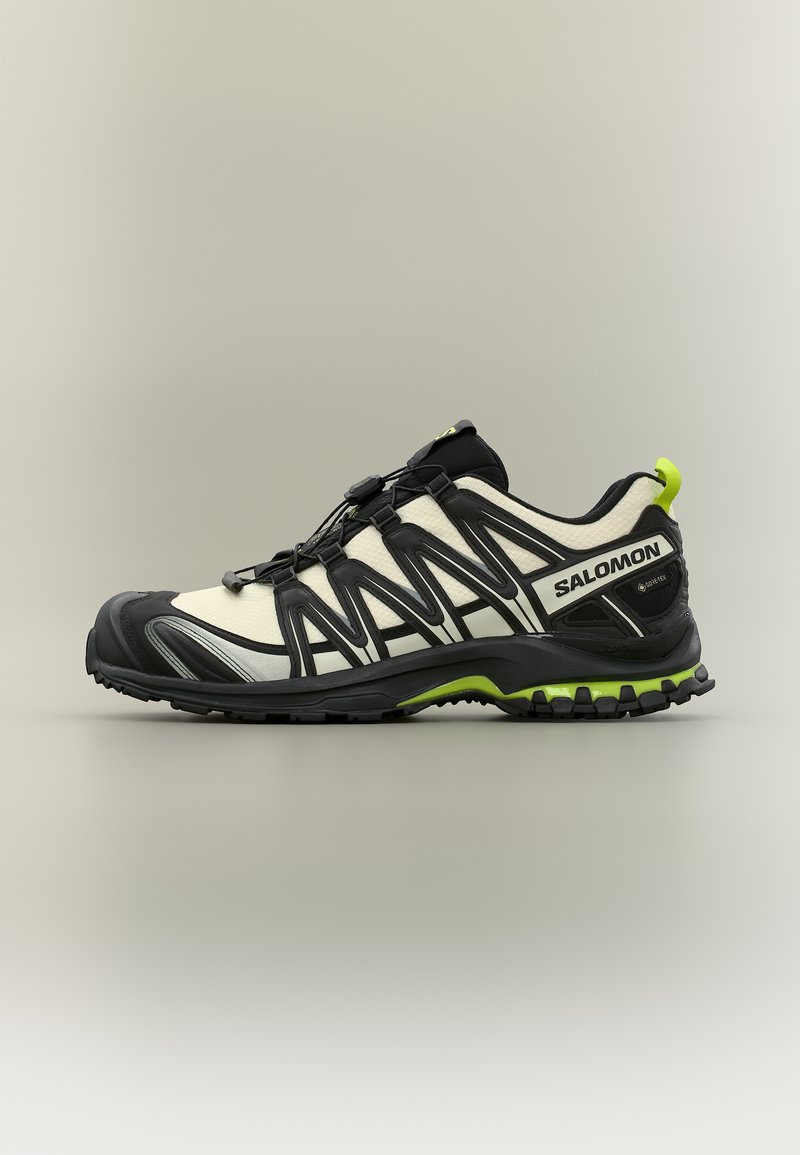 Μπεζ και μαύρο παπούτσι για τρέξιμο σε μονοπάτια Salomon με μαύρη σόλα, λαχανί λεπτομέρειες, σύστημα γρήγορου δέσιμου και άνω μέρος από διαπνέον ύφασμα, πλευρική όψη.