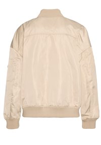 Beige Bomberjacke aus glattem, glänzendem Material. Verfügt über einen gerippten Kragen und Bündchen, einen elastischen Saum und keine sichtbaren zusätzlichen Details.