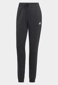 Fekete melegítőnadrág, húzózsinórral a derékrésznél, szűkített lábszárakkal és bordás mandzsettákkal. A bal combon egy kis fehér Adidas logó található.
