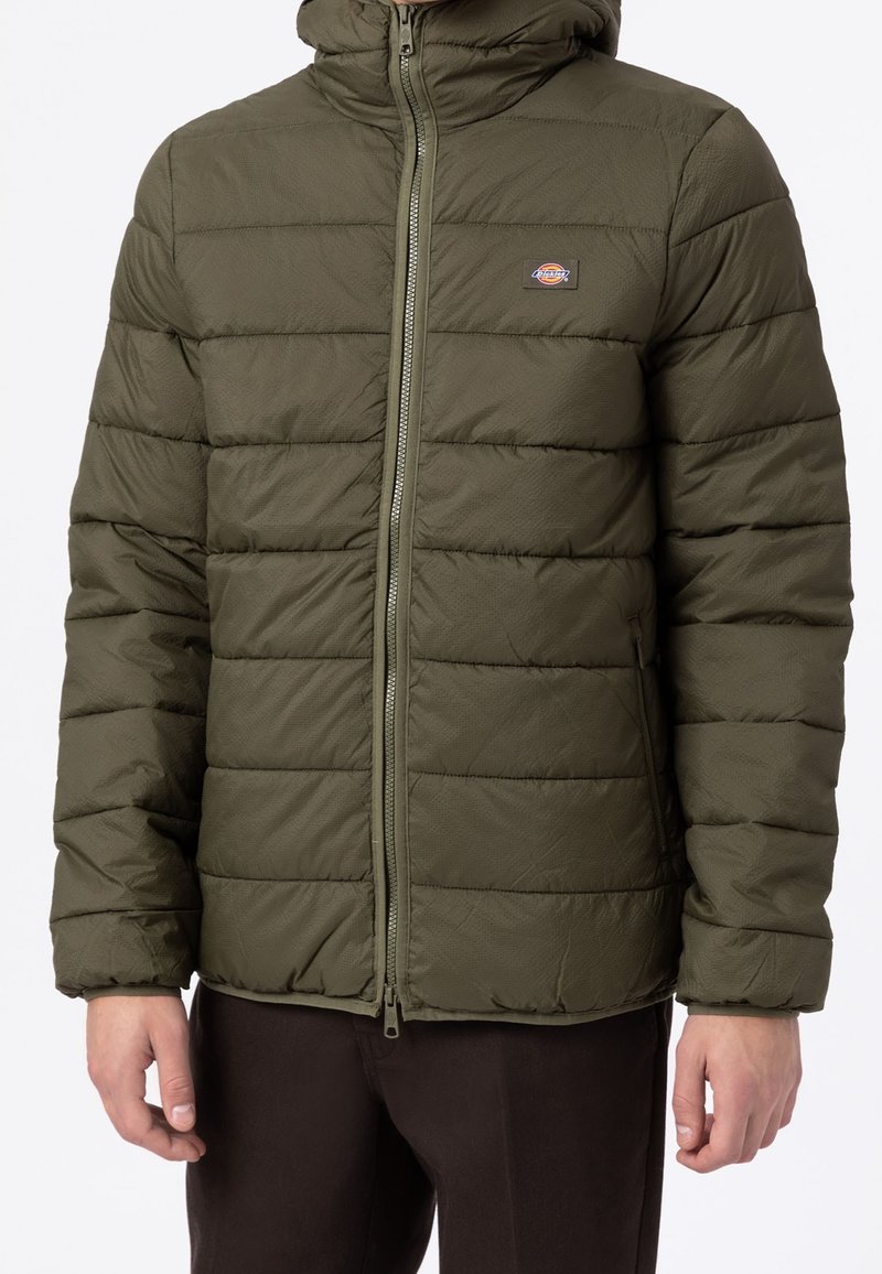 Kurtka puchowa w oliwkowym kolorze, pikowany wzór, zamek błyskawiczny, regulowany kaptur, lekki syntetyczny materiał, z logo na piersi.