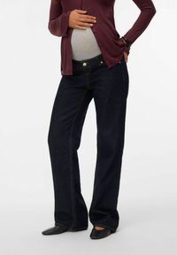 Graviditetsjeans i mörkblå denim, med avslappnad passform, kontrastsöm och hög midja för att rymma en växande mage.