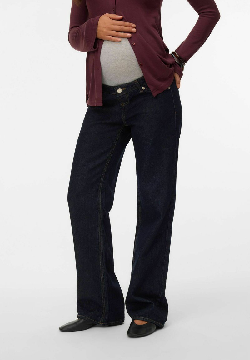 Graviditetsjeans i mörkblå denim, med avslappnad passform, kontrastsöm och hög midja för att rymma en växande mage.