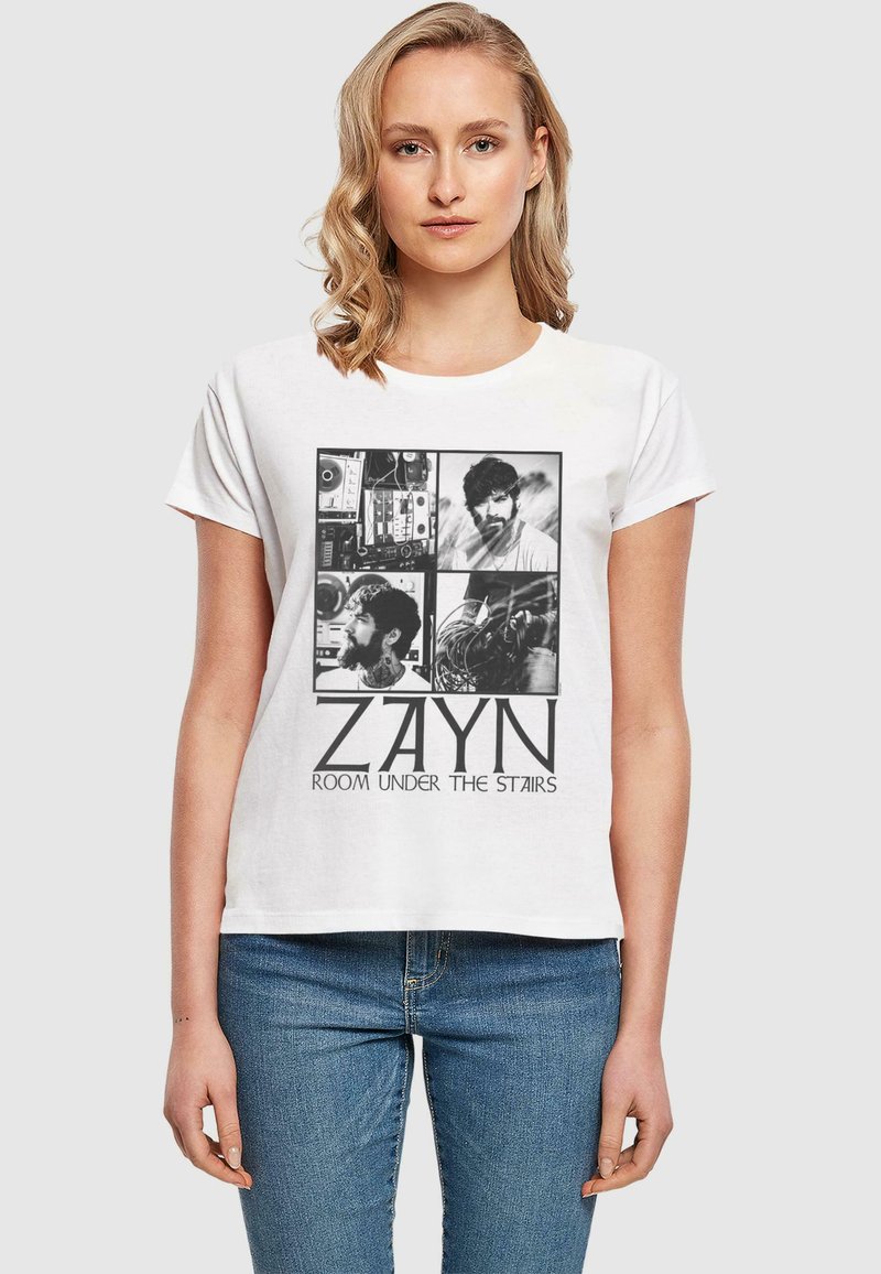 Valkoinen puuvillapaita, jossa on musta graafinen suunnittelu, joka sisältää neljä mustavalkoista kuvaa ja tekstin "ZAYN ROOM UNDER THE STAIRS" lihavoituna.