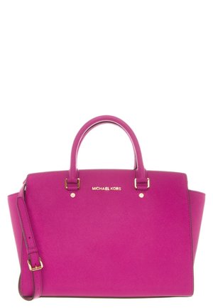 Lyserød Michael Kors håndtaske med to håndtag og en justerbar skulderrem, guldhardware og logo centreret på forsiden.
