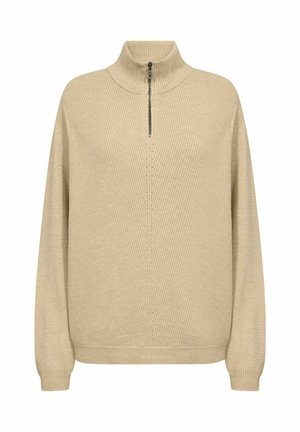 Beež ribaga sülle, millel on kõrge krae ja veerand-tõmblukk. Omaduseks on pikad varrukad, lõdva lõike ja tekstuuriga kudumismuster.