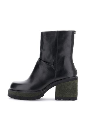 Stivaletto ankle in pelle nera con tacco a blocco verde testurizzato. Superficie liscia, punta tonda e chiusura con zip laterale. Silhouette moderna.