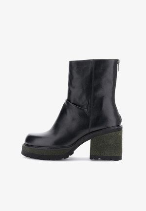 Černé kožené kotníkové boty s texturovaným zeleným blokovým podpatkem. Hladký povrch, kulatá špička a boční zip. Moderní silueta.