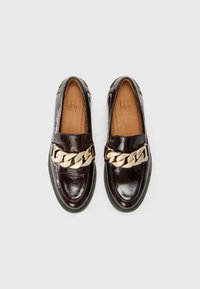 Dark brown glossy loafers with a chunky gold chain accent across the front and a black rubber sole. Interior features tan leather lining.