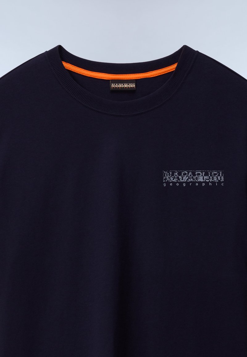 T-shirt en coton bleu marine avec col rond, ornée d'un petit logo graphique bleu clair sur la poitrine gauche et d'un accent orange à l'intérieur du col.