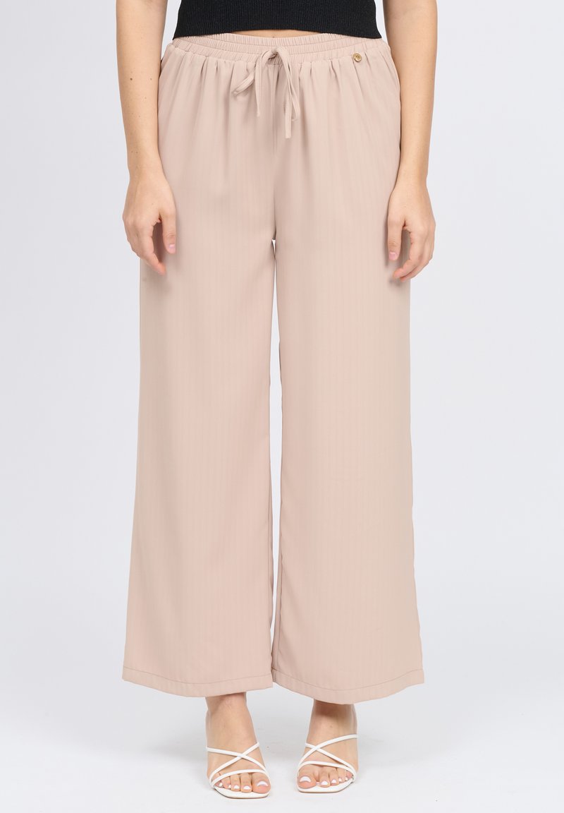 Pantaloni beige a gamba larga realizzati in materiale leggero. Presentano una vita elastica con cordoncino e una sottile texture a coste verticali.