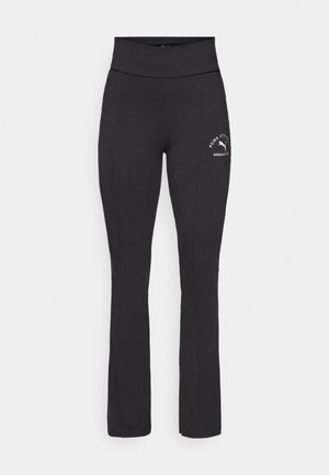 Pantalons de sport noirs avec une large taille, dotés de coutures latérales et d'un logo doré sur la cuisse gauche. Fabriqués en tissu extensible pour plus de confort.