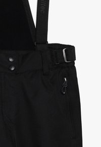 Pantaloni neri con bretelle regolabili, dotati di tasca con zip, passanti per cintura e due chiusure a bottone. Tessuto liscio con finitura opaca.