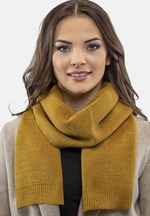 Écharpe tricotée jaune moutarde avec une texture douce, présentant un design large et replié, ainsi que des extrémités côtelées pour plus de détail.