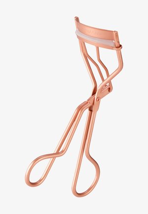 Recourbe-cils en or rose avec coussinet en silicone blanc, doté de poignées de style ciseaux et d'une pince supérieure incurvée pour recourber les cils.