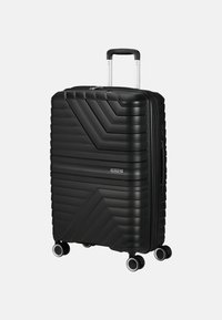 Valigia rigida nera con motivo a zigzag testurizzato, manico retrattile e quattro ruote girevoli per una facile mobilità.