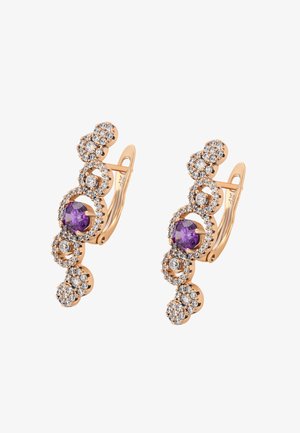 Arany színű fülbevalók köralapú mintákban, lila és átlátszó drágakövekkel díszítve. Textúrált fém, csillogó részletekkel.