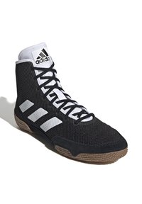 Svart och vit Adidas högsko atletiska sko med svarta snören och brun texturerad sula, med tre vita sidostrikar och logotyp på tungan.