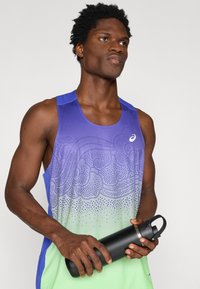 Ανδρικό αθλητικό μπλουζάκι αμάνικο με σχεδιασμό κλίμακας χρωμάτων από μωβ σε πράσινο, με υφή και μαύρο μπουκάλι νερού.