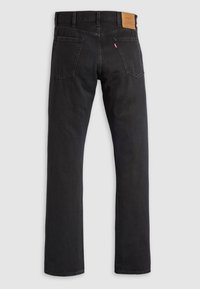 Zwarte denim jeans met een recht ontwerp, voorzien van een leren merkpatch aan de achterkant, twee achterzakken en minimale stikkingsdetails.