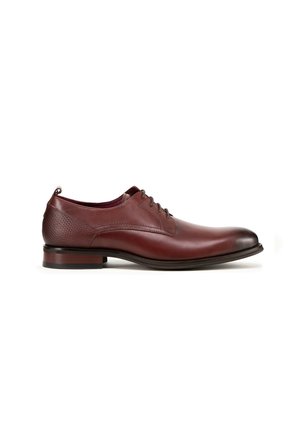 Bruine leren dresschoenen met een gladde oppervlakte, ronde neus en vetersluiting. Beschikt over gestructureerde accenten op de hak en een lage stapelzool.