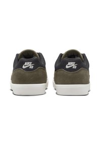 Tenisky Nike SB s černou síťovinou na horní části a olivově zeleným semišem na patě. Bílá gumová podrážka. Na zadní straně je logo Nike.