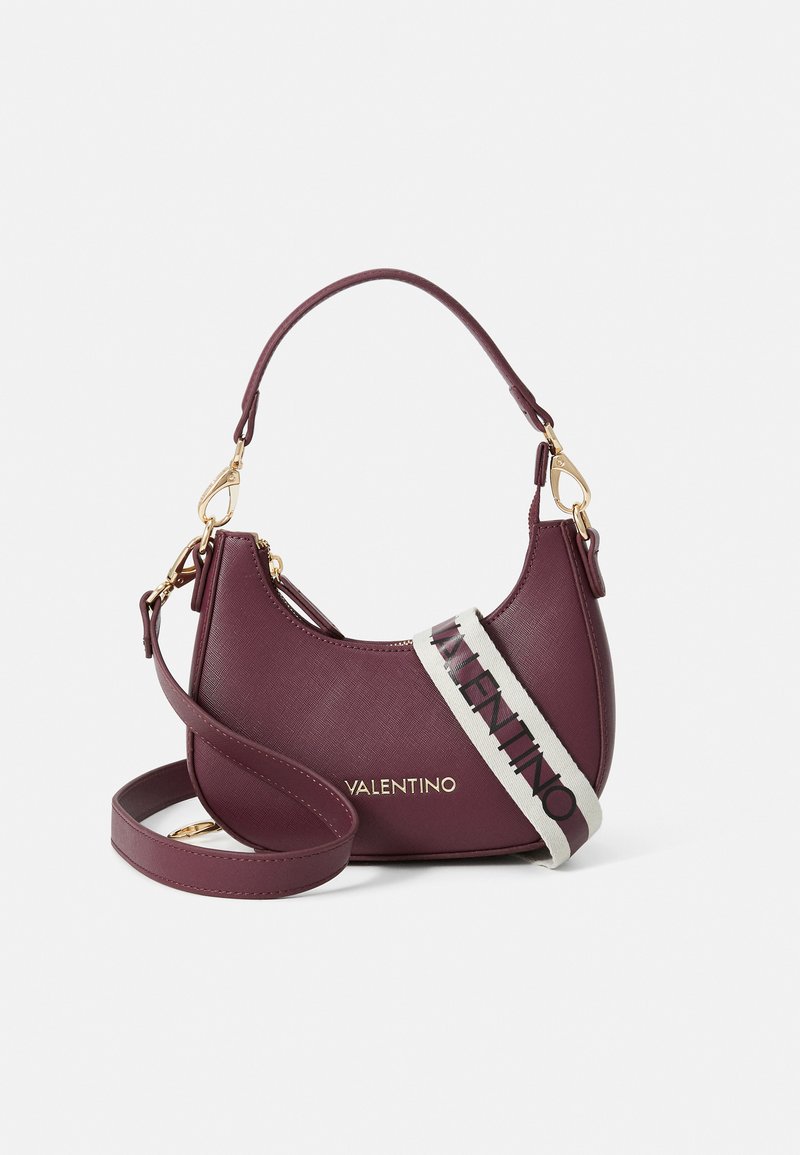 Geantă de piele burgundy cu o formă curbată, accesorii din aur și o curea albă cu text. Include o curea de umăr detașabilă.