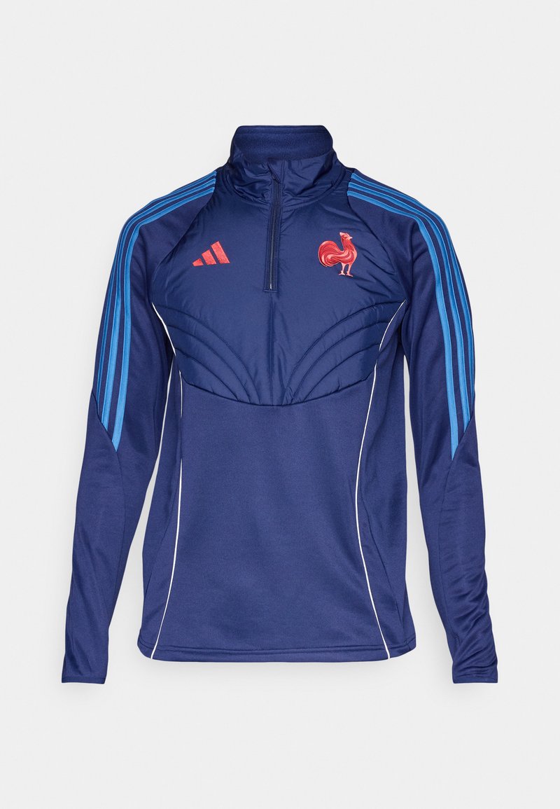 Veste de sport marine avec un col haut, une fermeture éclair et des rayures bleues. Présente un emblème de coq rouge et des coutures décoratives au niveau de la poitrine.