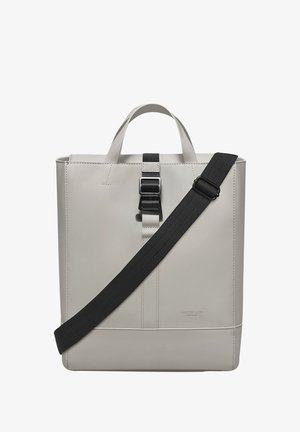 Grå, strukturert totebag med en jevn overflate, topphåndtak og avtakbar svart skulderreim. Har en sentral spenneåpning.