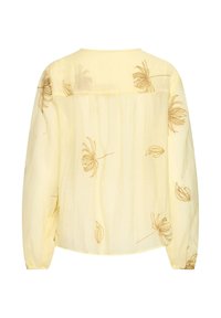 Blouse jaune clair à manches longues avec broderie florale marron, coupe ample et poignets élastiqués froncés, vue de dos.
