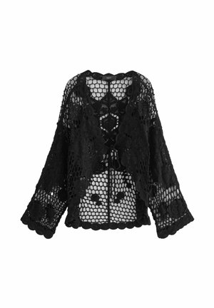 Cardigan en dentelle noire avec un large col, une ouverture à l'avant et des manches longues amples. Des motifs floraux intriqués et des bords festonnés dans tout le vêtement.