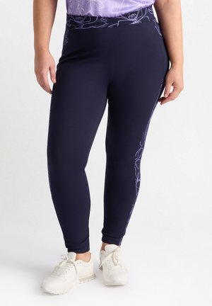 Leggings blu navy con texture liscia, caratterizzati da un delicato motivo floreale color lavanda lungo i lati, vita elastica e vestibilità affusolata.