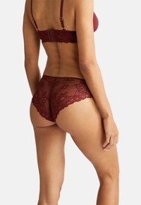 Completo di reggiseno bordeaux e culotte in pizzo con dettagli in pizzo floreale, tessuto morbido e design a scallop. Spalline regolabili con chiusura sul retro.