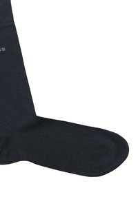 Calzino blu navy scuro con una texture liscia, polsino a coste e punta rinforzata. Presenta un dettaglio logo sottile vicino al polsino.