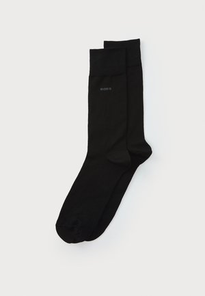 Schwarze Baumwollsocken mit einem einfarbigen Design, ausgestattet mit einem gerippten Bündchen und einem dezenten Logo, das seitlich aufgedruckt ist. Weicher Griff und Standardform.