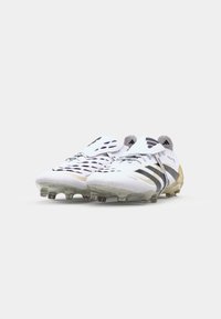 White football boots with black and gold accents, featuring a sleek design, textured upper, and molded studs for traction.