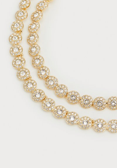 Collier en ton doré avec des maillons circulaires, chacun comportant une pierre transparente centrale entourée de petites gemmes, affichant une finition texturée.