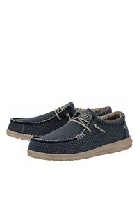 Bottines en toile de couleur bleu foncé avec une surface texturée, des coutures contrastantes de couleur blanc cassé, une semelle beige et une doublure intérieure à motifs.